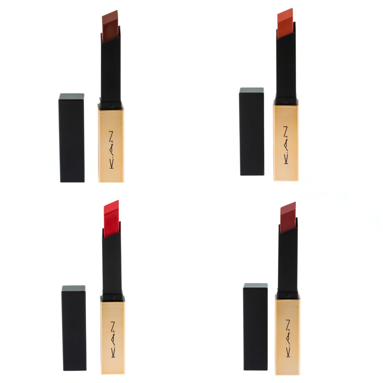 Set of four luxury lipsticks in gold and black cases on white background